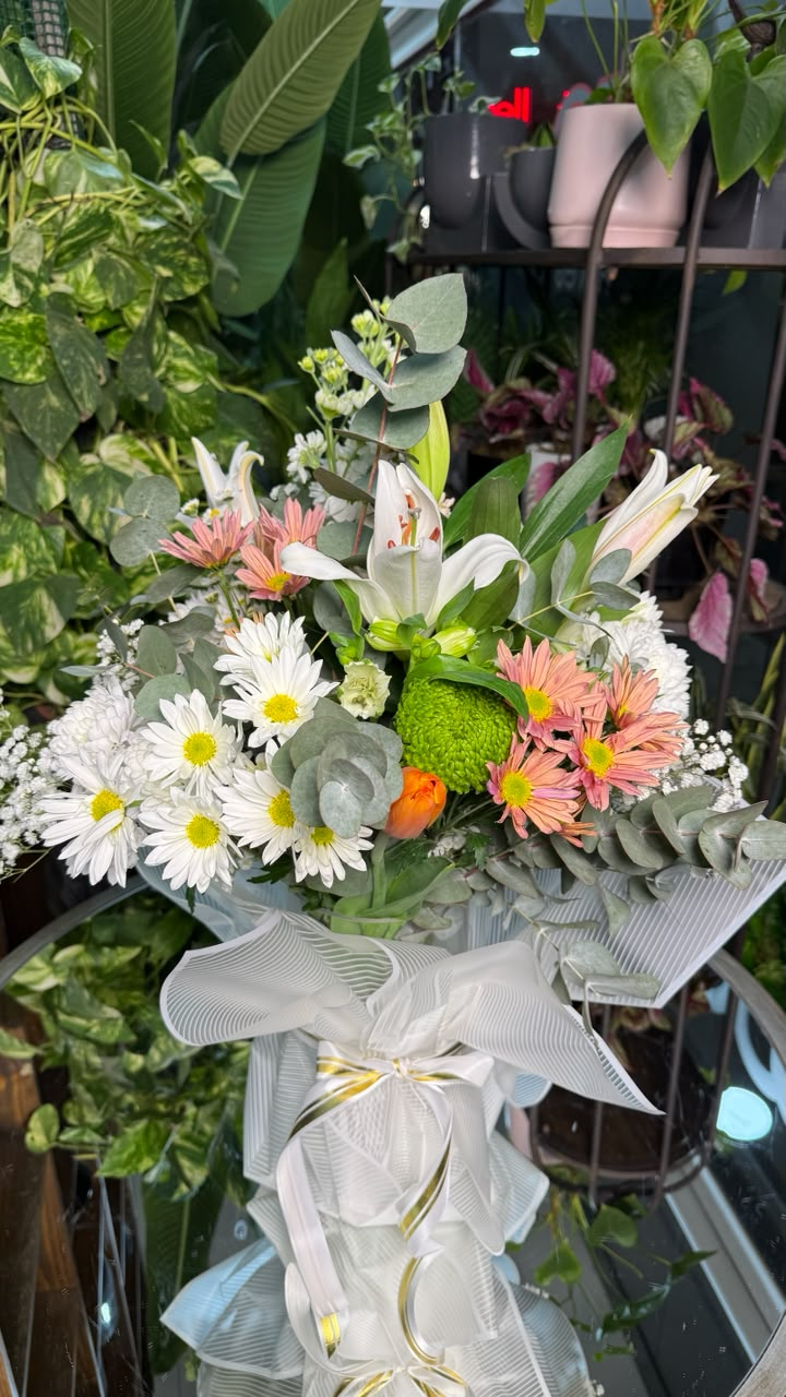 Ramo floral en florero de cristal con lilium perfumado, tulipanes, crisantemos, rosas y margaritas